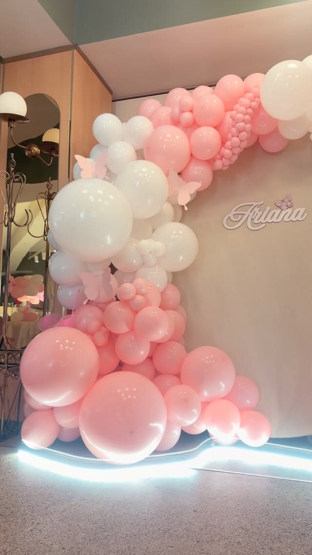 Arcadă din baloane roz și albe cu fluturi, decor pentru o petrecere de fetiță